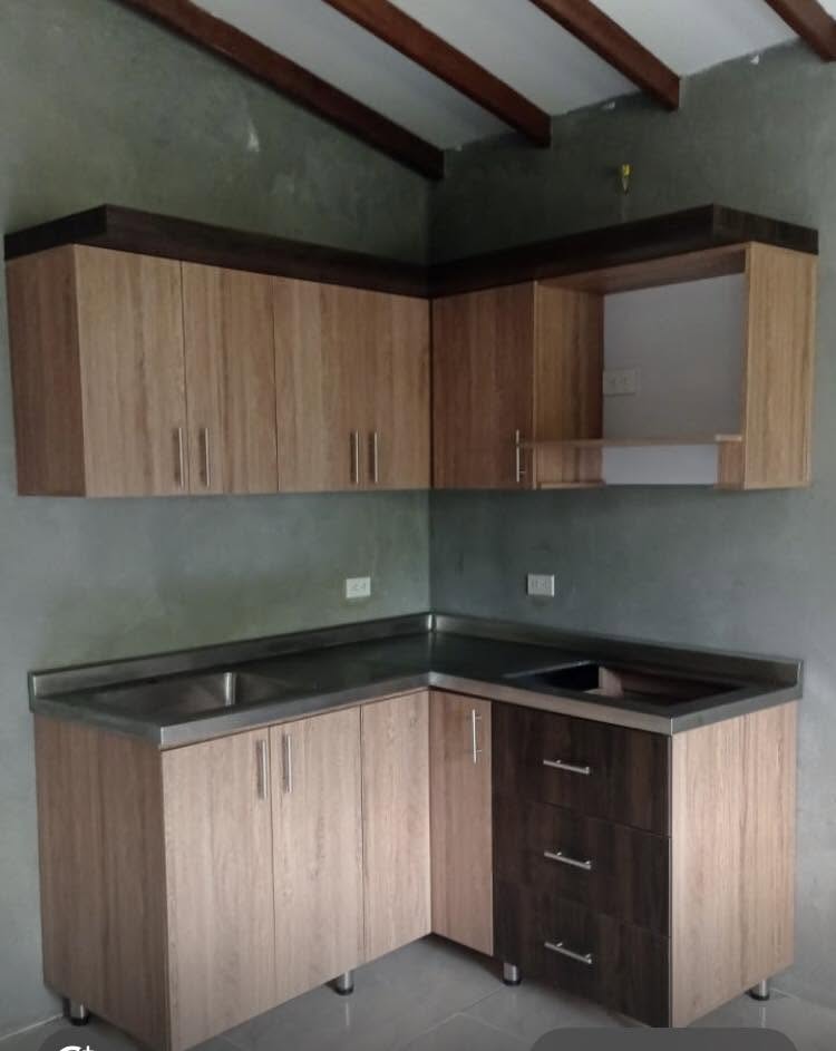 Cocina integral en L en madera clara con mesón en acero