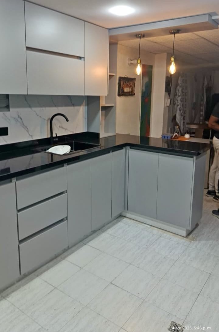 Cocina gris mate en U con mesón en granito negro y barra
